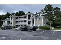 Attractive condo building with stacked balconies, well-maintained landscaping, and ample parking at 971 Blue Stem Dr. # 41 H, Pawleys Island, SC 29585