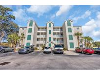 Condo building with multiple units, manicured landscaping, and ample parking on a sunny day at 1100 Commons Blvd. # 1001, Myrtle Beach, SC 29572