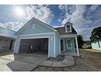 Charming home featuring a light blue exterior, attached garage, and covered front porch at 1229 Lady Bird Way, North Myrtle Beach, SC 29582