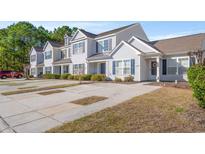 Charming townhouse featuring neat landscaping, symmetrical windows and shutters, and private parking at 1298 Harvester Circle # 1298, Myrtle Beach, SC 29579