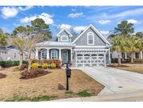 Charming home featuring a welcoming entrance, a well-manicured lawn, and a stylish grey and white color scheme at 3065 Moss Bridge Ln., Myrtle Beach, SC 29579
