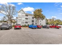 Condo exterior featuring gray siding, multi-pane windows, and ample parking in a well-maintained community at 351 Lake Arrowhead Rd. # 12-347, Myrtle Beach, SC 29572