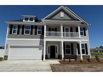 Two-story home with white siding, covered porch, black shutters, and an attached two car garage at 4008 Bucolic Loop, Myrtle Beach, SC 29588
