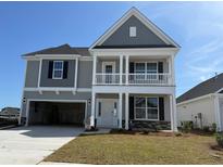 Charming two-story home featuring a welcoming front porch, attached garage, and well-manicured lawn, offering instant curb appeal at 4035 Bucolic Loop, Myrtle Beach, SC 29588
