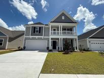 Charming two-story home featuring a balcony, attached garage, and well-manicured lawn at 4035 Bucolic Loop, Myrtle Beach, SC 29588