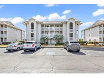Condo exterior with palm trees, multiple levels, and assigned parking under sunny skies at 4413 Eastport Blvd. # F-1, Little River, SC 29566