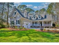 Charming home featuring dormers and a welcoming front porch, surrounded by lush landscaping at 4514 Wagon Run Circle, Murrells Inlet, SC 29576