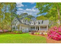 Charming home with lush landscaping, inviting front porch, and attached two-car garage at 4514 Wagon Run Circle, Murrells Inlet, SC 29576