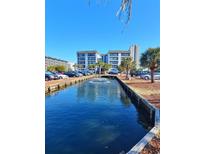 Scenic view of a water feature in front of a condo complex, reflecting a bright blue sky at 5905 S Kings Hwy. # 216B, Myrtle Beach, SC 29577