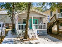 Charming beach house with a cozy front porch and vibrant turquoise door, creating a welcoming coastal ambiance at 6001- 1222 S Kings Highway, Myrtle Beach, SC 29575