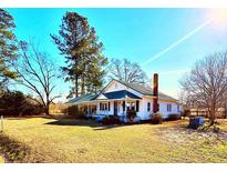 Charming single-story home with a green roof, white siding, and a welcoming front porch, set on a spacious lawn at 6733 High Point Church Rd., Conway, SC 29527