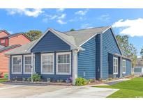 Charming blue home featuring a well-maintained yard and beautiful landscaping at 1006 Charles St., North Myrtle Beach, SC 29582