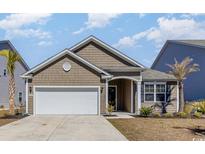 Charming single-story home with a well-manicured lawn, attached garage, and inviting front porch at 10141 Hamilton Branch Loop, Myrtle Beach, SC 29579