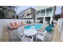 Inviting backyard pool area with outdoor seating, lounge chairs, and stylish landscaping, perfect for relaxation and entertaining at 113B 13Th Ave. N, Surfside Beach, SC 29575