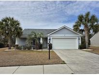 Charming single-story home with a two-car garage, well-manicured lawn, and mature palm trees at 1261 Pineridge St., Conway, SC 29527