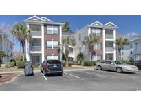 Condo building exterior featuring well-maintained landscaping and ample parking spaces at 1294 River Oaks Dr. # 6E, Myrtle Beach, SC 29579