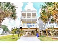 Three-story beach house featuring multiple balconies and covered parking at 1614-B S Ocean Blvd., Surfside Beach, SC 29575