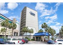 Lovely condo exterior with blue awning, palm trees and blue skies on a sunny day at 200 76Th Ave. N # 410, Myrtle Beach, SC 29572