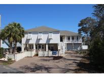 Inviting coastal home with brick driveway, lush landscaping, and a charming facade at 220 Starcrest Circle, North Myrtle Beach, SC 29582