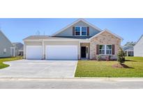 Charming two-story home with a stone facade and a two-car garage, plus a manicured lawn at 309 Mayflower Dr., Calabash, NC 28467