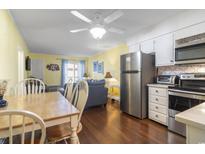Open-concept living area featuring a dining table, stainless steel appliances, and cozy furnishings at 401 Hillside Dr. N # 2F, North Myrtle Beach, SC 29582