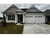 Charming single-Gathering home with a two-car garage, manicured lawn, and covered front porch at 4028 Bucolic Loop, Myrtle Beach, SC 29588