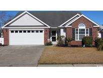Charming single-story home features a brick facade, attached garage, and well-maintained front yard at 449 Pennington Loop, Myrtle Beach, SC 29588