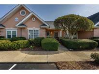 Charming home with manicured landscaping, inviting walkway, and peach stucco exterior at 4545 Lighthouse Dr. # 28C, Little River, SC 29566