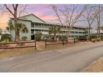 Three-story building showcasing multiple balconies with scenic views, surrounded by mature trees and meticulous landscaping at 5905 South Kings Hwy. # 4107-D, Myrtle Beach, SC 29575