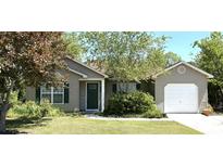 Charming single-story home with a well-manicured lawn and green front door at 6006 Quinn Rd., Myrtle Beach, SC 29579