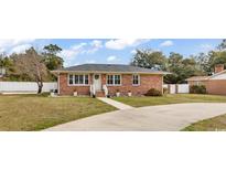 Charming brick home featuring a well-manicured lawn and a classic, welcoming facade at 7714 Woodland Dr., Myrtle Beach, SC 29572