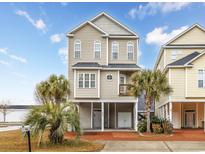 Inviting three-story beach home featuring a charming coastal design and well-manicured landscaping at 102-A N Poplar Dr., Surfside Beach, SC 29575