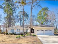 Inviting single story home featuring a two car garage, well-maintained lawn, and mature shade trees at 1043 Yellow Jasmine Dr., Longs, SC 29568