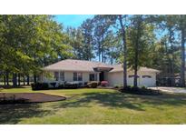 Charming one-story home with a well-manicured lawn, beautiful landscaping, and an attached two-car garage at 1043 Yellow Jasmine Dr., Longs, SC 29568