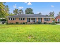 Charming brick home with a well-manicured lawn and blue shutters, creating a welcoming curb appeal at 115 Carolina Ave., Mullins, SC 29574