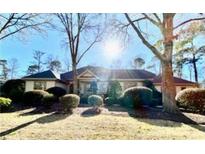 Charming single-story home featuring manicured landscaping and a classic architectural design, nestled among mature trees at 1208 Tidewater Dr., North Myrtle Beach, SC 29582