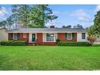 Charming brick home with a well-manicured lawn and mature trees creating a welcoming curb appeal at 1300 Anderson St., Conway, SC 29526