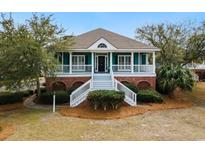 Charming single-story home featuring a welcoming front porch and landscaped front yard with brick foundation at 165 Marsh Lake Dr. # 27, Georgetown, SC 29440