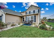 Charming front yard featuring a well-manicured lawn, landscaping, and inviting front porch with seating at 177 Tibton Circle, Myrtle Beach, SC 29588