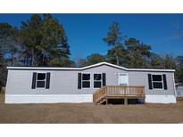 Well maintained gray single Gathering home with black shutters and wooden front deck at 2016 Misty Morning Dr., Conway, SC 29527