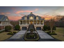 Stately two-story home with a brick base, fountain, lush landscaping, and a grand staircase leading to a covered porch at 208 Wahee Pl., Conway, SC 29527
