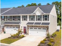 Charming townhome featuring stone accents, a one-car garage, and a neatly landscaped front yard at 308 Golan Circle # A, Myrtle Beach, SC 29579