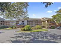 Charming condo complex featuring multiple levels, lush landscaping, and an inviting entrance at 410 Melrose Pl. # 308, Myrtle Beach, SC 29572