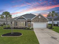 Charming brick home boasts manicured lawn, mature trees, and a convenient two-car garage in a beautiful community at 419 Broadmoor Dr., Murrells Inlet, SC 29576