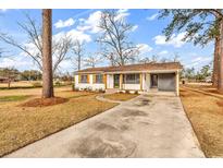 Charming one-story home featuring a brick exterior, mature trees, and a spacious front yard with a private driveway at 4320 Stevens St., Loris, SC 29569