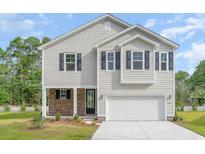 Charming two-story home with a stone-accented porch and a two-car garage, set against a backdrop of trees at 6031 Forest Dell Ct, Myrtle Beach, SC 29579