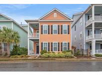 Charming, two-story home featuring a balcony, tidy landscaping, and colorful exterior at 7809 Monarch Dr., Myrtle Beach, SC 29572