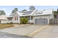 Charming single-story home with a metal roof, solar panels, and an attached garage at 810 Finger Lake Dr., Myrtle Beach, SC 29588