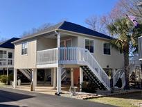 Charming raised beach home with white railings, staircases, and pleasing color palette at 820 9Th Ave. S, North Myrtle Beach, SC 29582