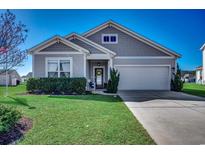 Charming single-story home featuring a well-maintained lawn, attached garage, and a welcoming entryway at 1056 Caprisia Loop, Myrtle Beach, SC 29579